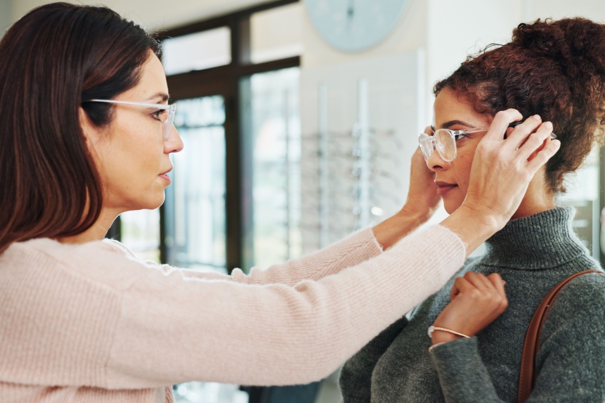 An optician helping a patient get the right fit for their glasses